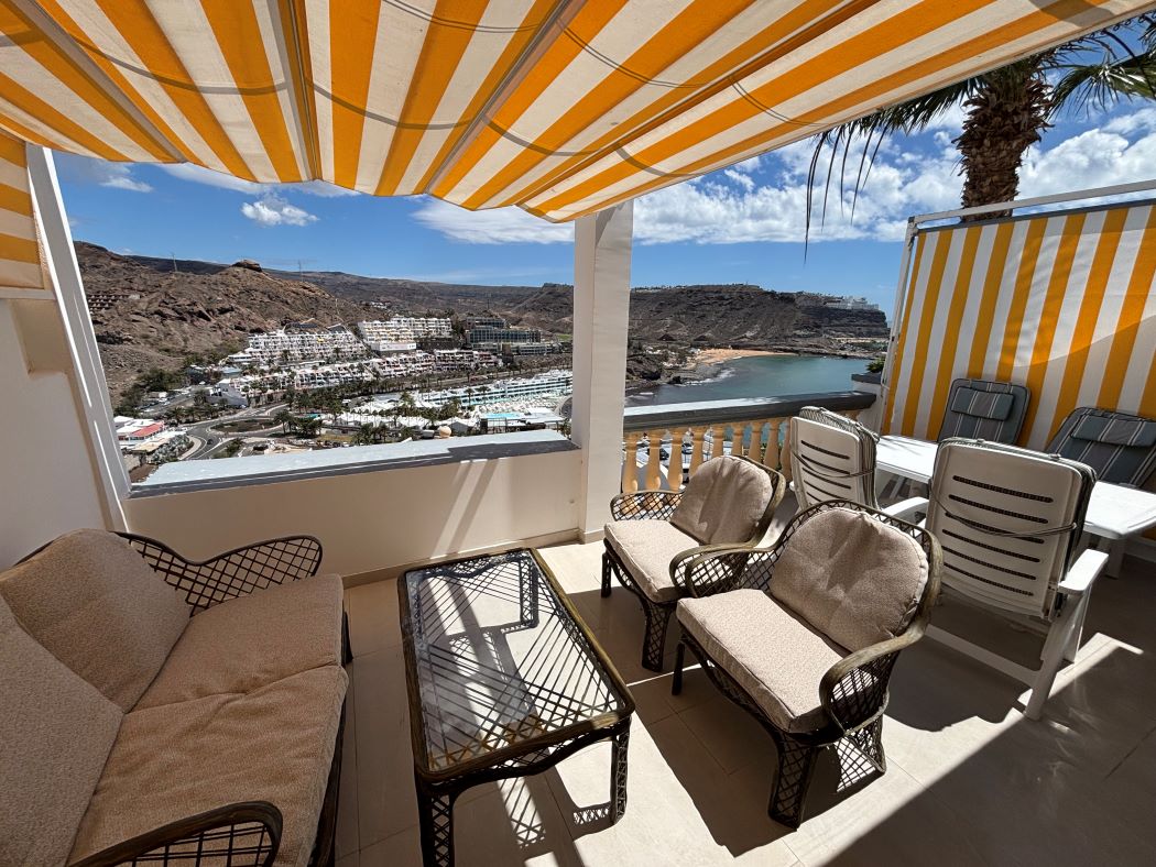 Private terrace with yellow-and-white awning, outdoor furniture and sea view
